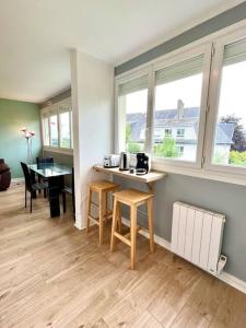 a kitchen with a table and two stools in a room at Khara - SILS in Caen