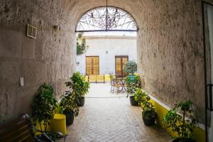 un couloir avec des plantes en pot dans un bâtiment dans l'établissement Hotel Tierrasur, à Arequipa