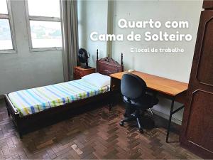 Schlafzimmer mit einem Schreibtisch, einem Bett und einem Schreibtischstuhl in der Unterkunft Apartamento em Vitória capital do ES in Vitória