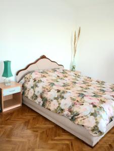een bed met een bloemdekbed in een slaapkamer bij Holiday home White House in Bar