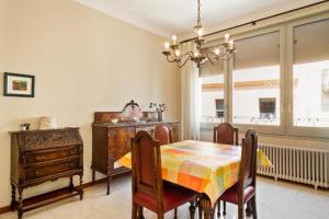 een eetkamer met een tafel en stoelen en een kroonluchter bij Apartament Centre Vila Figueres in Figueres