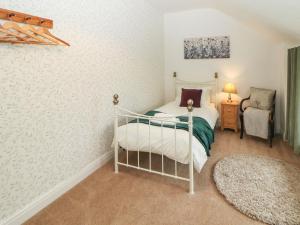 a bedroom with a bed and a chair at 3 Moorview in Buxton