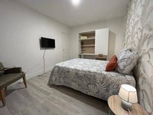 a bedroom with a bed and a flat screen tv at LeRelaisdOdile * APPARTEMENT PARTAGE Spacieux & Lumineux * in Cambrai