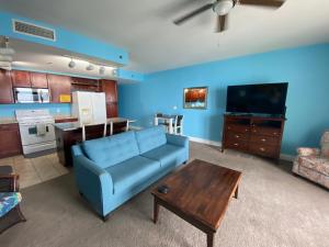 a living room with a blue couch and a table at Laketown Wharf 1717 in Panama City Beach