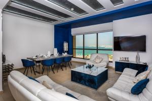 a living room with a white couch and a table at Elan Rimal Suites JBR Beach Sea View in Dubai