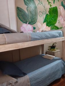 two bunk beds in a room with a wall with flowers at Dante y compañía in Buenos Aires