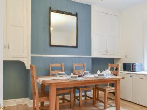 a dining room table with chairs and a mirror at Sunnyside Hestbank in Hest Bank