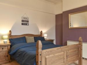 een slaapkamer met een houten bed en een spiegel bij Sunnyside Hestbank in Hest Bank