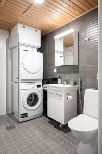 uma casa de banho com uma máquina de lavar roupa e um WC em Apartment near the train station, free parking &Netflix em Kuopio