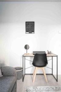 a desk with a black chair in a living room at Apartment near the train station, free parking &Netflix in Kuopio