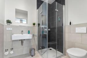 a bathroom with a shower and a toilet and a sink at Flatista Homes - Aubing in Munich
