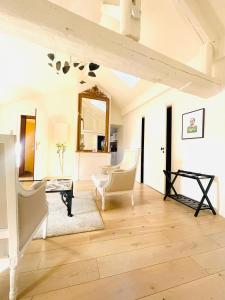 sala de estar con muebles blancos y espejo. en Loft Le Saint Louis by La Chambre à Coté, en Metz