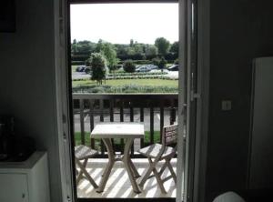 a view of a table and chairs from a door at 2 pièces ensoleillé accès direct plage in Cabourg