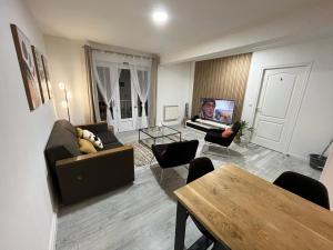 a living room with a couch and chairs and a tv at LeRelaisdOdile * APPARTEMENT PARTAGE Spacieux & Lumineux * in Cambrai