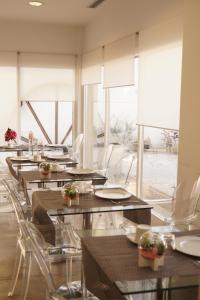 un comedor con mesas, sillas y ventanas en Hotel El Patiaz de la Reina Rana, en Tauste