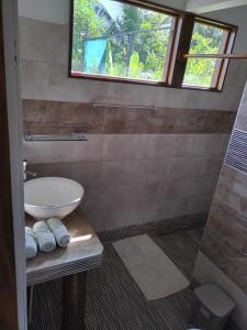 baño con aseo y lavabo y ventana en El Campo, en Savegre