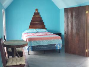 1 dormitorio con cama y pared azul en Posada Don Julio en Flores