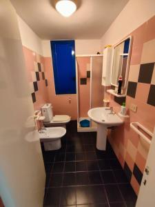 een badkamer met 2 wastafels en een blauw raam bij Villetta Blu Mare in Torre Vado