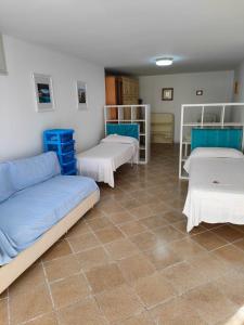 een kamer met 3 bedden en een tegelvloer bij Villetta Blu Mare in Torre Vado