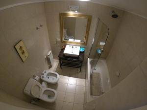 uma casa de banho com 2 WC, um lavatório e um espelho. em Amaneceres del Beagle em Ushuaia