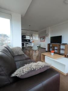 uma sala de estar com um sofá de couro e uma mesa em Amaneceres del Beagle em Ushuaia