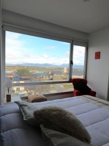 Amaneceres del Beagle في أوشوايا: غرفة نوم مع نافذة كبيرة مع سرير كبير