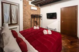 a bedroom with a large bed with red sheets at Zero45 San Martino Apartment in Grosseto