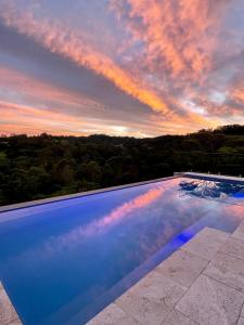 a swimming pool with a sunset in the sky at Mapleton Springs in Mapleton