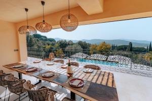 jadalnia ze stołem i krzesłami oraz dużym oknem w obiekcie Villa Joia w Saint-Tropez