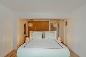 a bedroom with a large white bed with two pillows at Villa Joia in Saint-Tropez