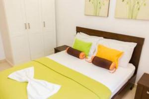 a bedroom with a bed with yellow and green pillows at Luxury Villa with Private Pool at Melia Tortuga Beach Resort in Santa Maria