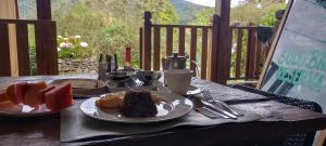 a table with a plate of food on a table with fruit at Finca Queveri in Orosí