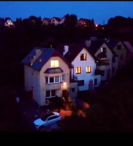 a white house with a car parked in front of it at Familia Apartament na wzgórzu 3 z sauną i salą zabaw dla dzieci in Gdynia