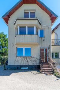 a house with a staircase in front of it at Familia Apartament na wzgórzu 3 z sauną i salą zabaw dla dzieci in Gdynia