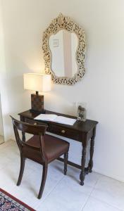 biurko z lampką i lustrem na ścianie w obiekcie Selwyn Cottage w Burnt Pine