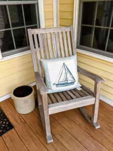 a wooden rocking chair with a pillow on a porch at Waterfront Getaway in Wethersfield