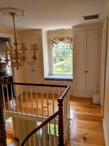 a staircase in a home with a window and a chandelier at Waterfront Getaway in Wethersfield
