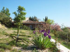 a garden in front of a house with flowers at Domaine La Fontaine Du Cade in Lagorce