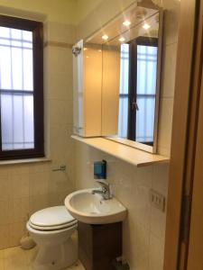 Appartamento civico 14 في Campoformido: حمام مع مرحاض ومغسلة ومرآة