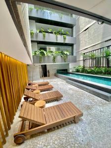 a row of benches in a building with a pool at Loft Exclusive frente Mar in Rio de Janeiro