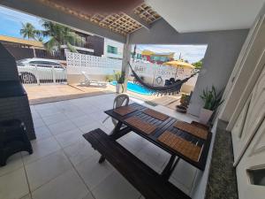 un patio con una mesa, una hamaca y una piscina en Casa cinza em frente à praia em condominio, en Aracaju