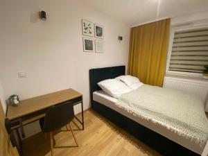 niewielka sypialnia z łóżkiem i biurkiem w obiekcie Apartament Spokojna Przystań w mieście Rzeszów