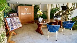 サン・フランシスコにあるHotel Ysuri San Panchoのテーブルと青い椅子2脚が備わるホテルルームです。