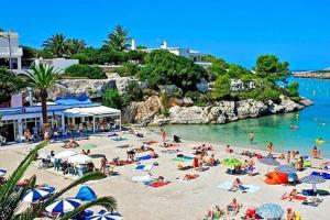een groep mensen op een strand in het water bij relax apartamento in Son Carrio