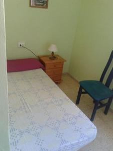 a bedroom with a bed and a chair and a lamp at relax apartamento in Son Carrio