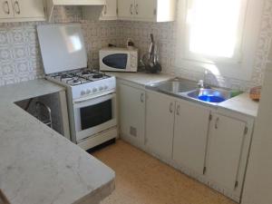 a kitchen with a stove and a sink and a microwave at relax apartamento in Son Carrio