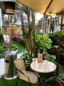 - une table et des chaises sous un parasol dans le jardin dans l'établissement Lima Wari Hotel Boutique, à Lima