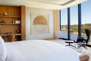 a bedroom with a bed and a living room with windows at The Ritz-Carlton, Perth in Perth