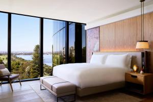 a bedroom with a large white bed and large windows at The Ritz-Carlton, Perth in Perth