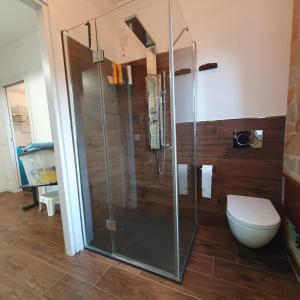 a bathroom with a toilet and a glass shower at Giancasavacanze in Alghero